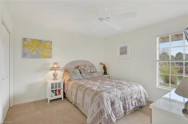 Bedroom featuring a closet, light carpet, and a ceiling fan