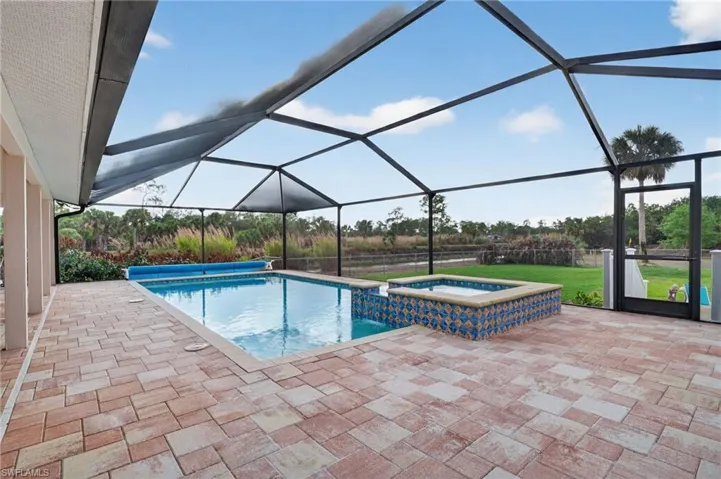 Integrated pool / hot tub featuring a sunroom, a patio, and a lanai