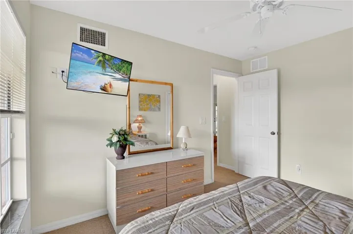 Bedroom with light colored carpet and ceiling fan
