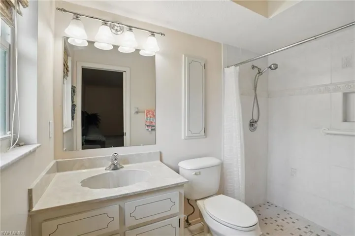 En suite master bathroom with a tile shower and vanity