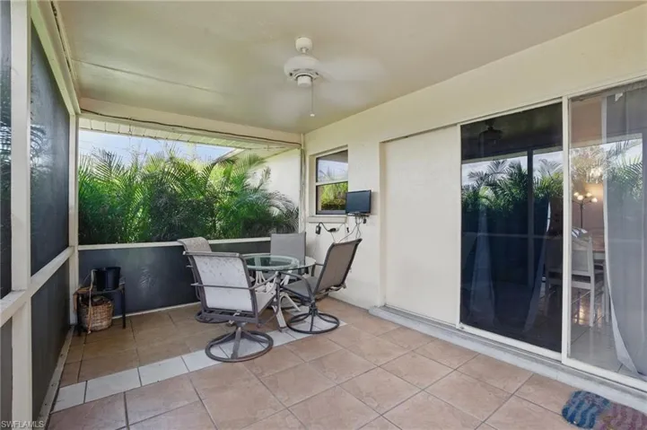 Screened lanai featuring ceiling fan and outdoor dining space