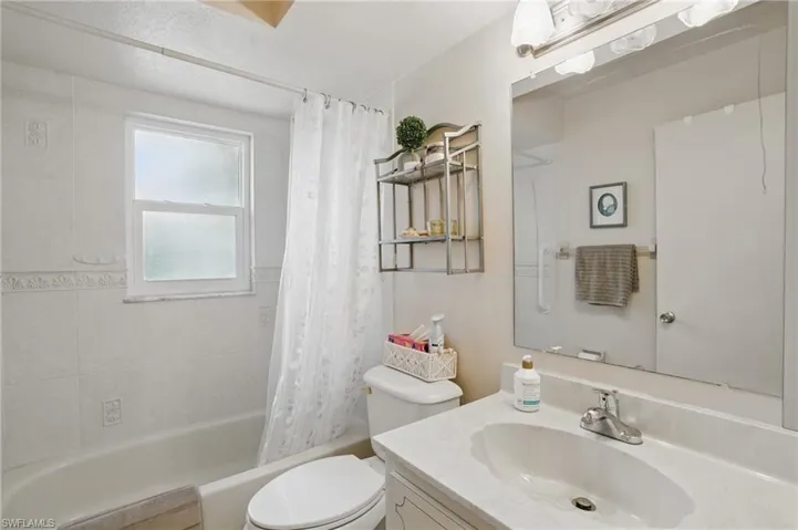 Guest bathroom featuring vanity, and shower / tub combo with curtain