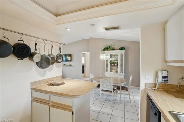Kitchen featuring light tile floors, window above sink, and recessed lighting.