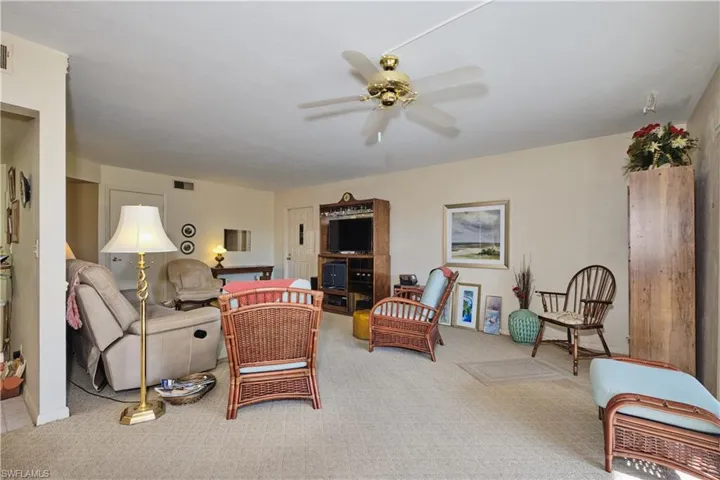 Carpeted living area with ceiling fan