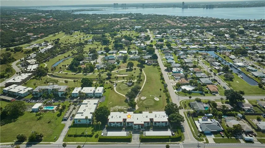 Aerial view of property and surrounding area featuring nearby suburban area