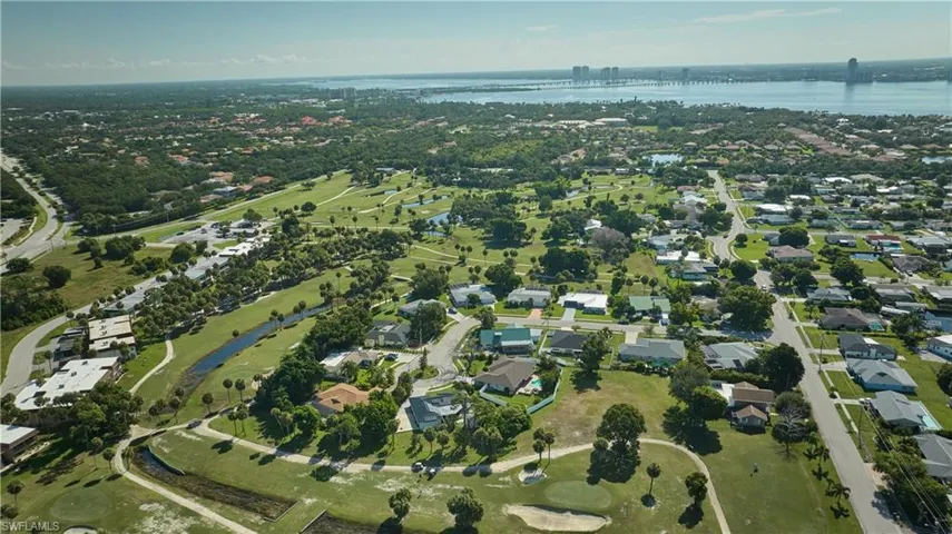 Aerial overview of property's location featuring a nearby body of water and nearby suburban area