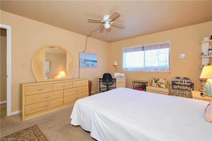 Bedroom with light colored carpet and ceiling fan
