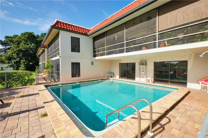 Community pool featuring a patio and a sunroom