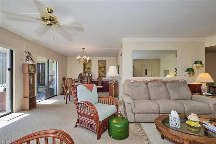 Carpeted living room with a chandelier and ceiling fan