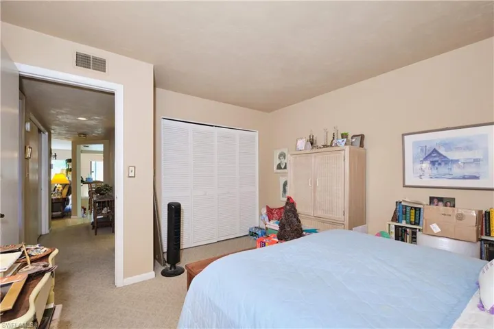 Bedroom featuring light colored carpet and a closet