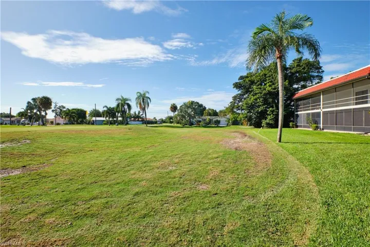View of green lawn featuring a sunroom