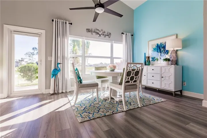 Dining space featuring ceiling fan, dark wood-type flooring, and a healthy amount of sunlight