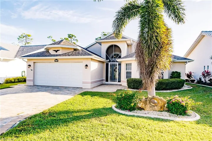 View of front of house with a front yard and a garage