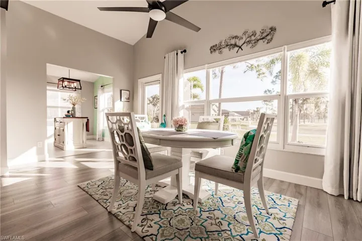 Dining room featuring plenty of natural light, light hardwood / wood-style floors, and ceiling fan with notable chandelier