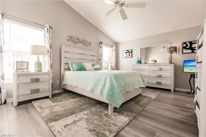 Bedroom with hardwood / wood-style flooring, ceiling fan, and high vaulted ceiling