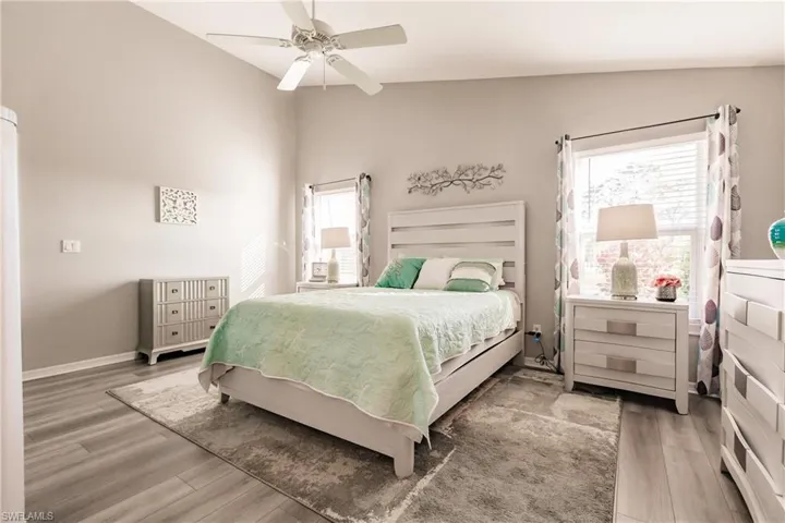 Bedroom featuring hardwood / wood-style flooring, ceiling fan, and multiple windows