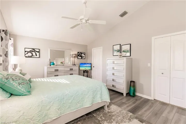 Bedroom featuring hardwood / wood-style flooring, ceiling fan, a closet, and vaulted ceiling