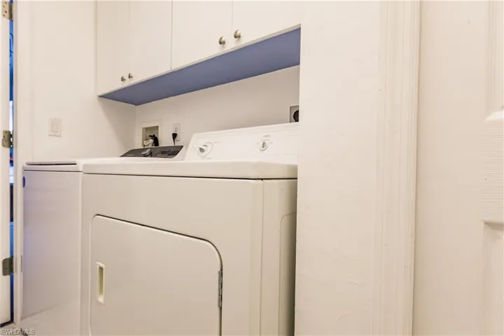 Laundry room featuring cabinets and washer and clothes dryer