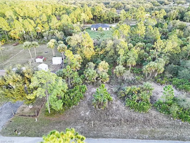 Aerial view of property and surrounding area with a forest