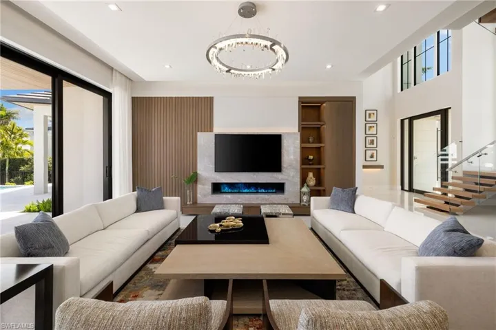 Living area with a fireplace, hanging lights, and built in features