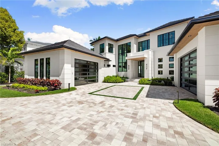 Modern home with stucco siding, decorative driveway, and an attached garage