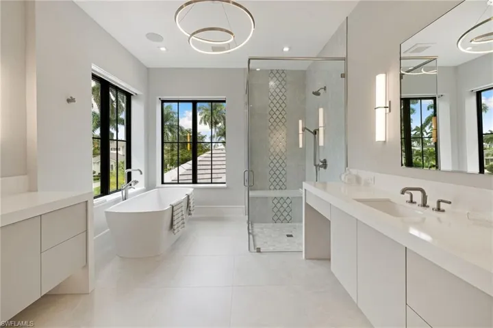 Bathroom featuring a freestanding tub, a shower stall, vanity, and light tile patterned floors
