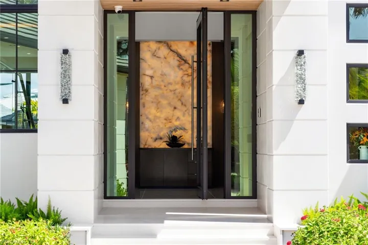 View of exterior entry with stone siding and stucco siding