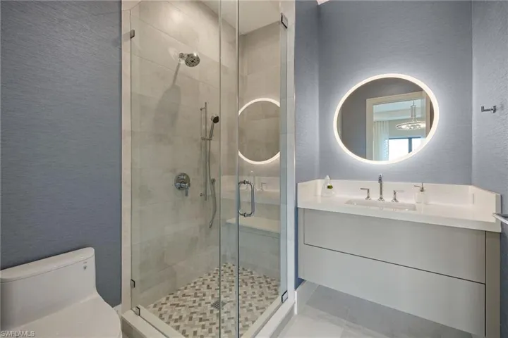 Full bath featuring a textured wall, a stall shower, and vanity