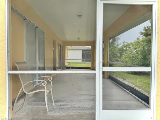 Unfurnished sunroom featuring concrete floors and a textured wall