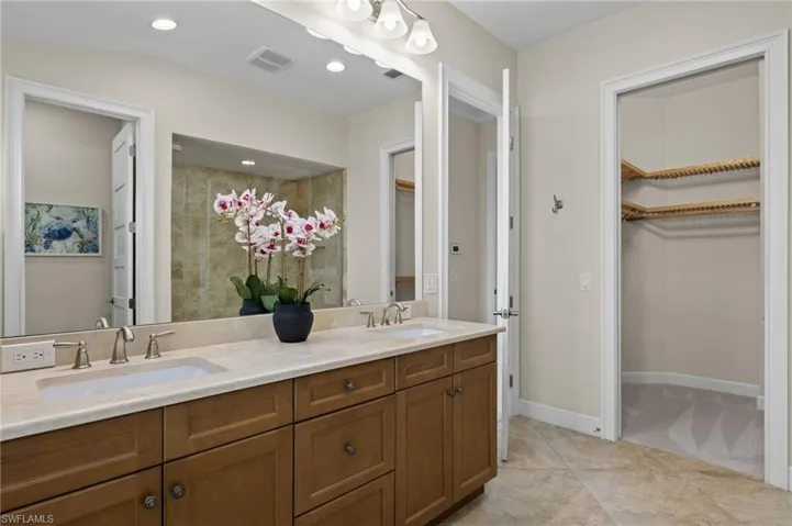 Bathroom featuring dual bowl vanity and tile patterned floors