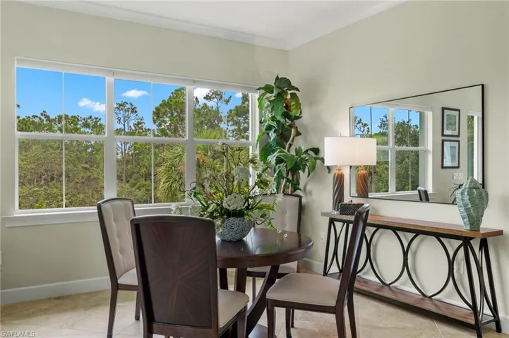 Tiled dining space featuring crown molding and a healthy amount of sunlight