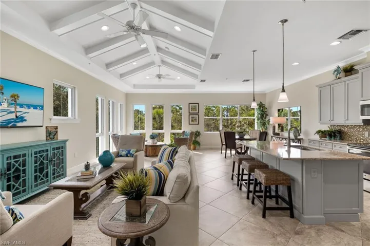 Tiled living room with sink, plenty of natural light, and ceiling fan