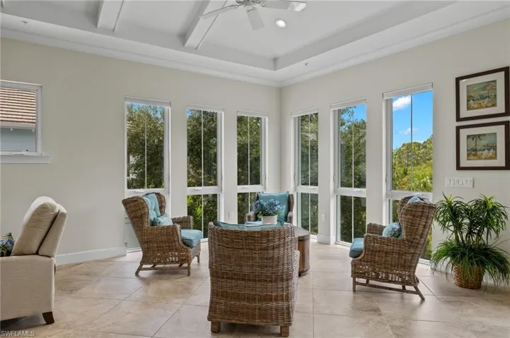 Sunroom with ceiling fan and beam ceiling and plenty of natural light