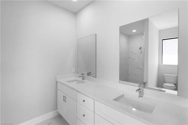 Bathroom featuring toilet and double vanity