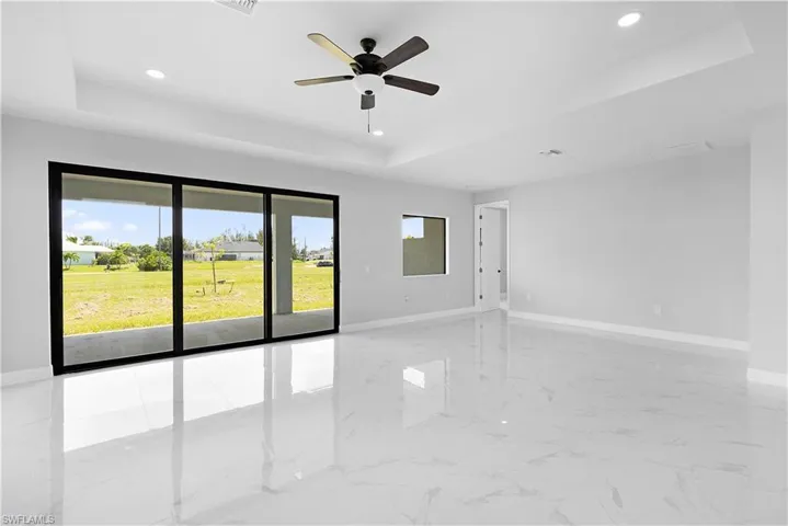 Unfurnished room featuring light tile patterned floors, a raised ceiling, and ceiling fan