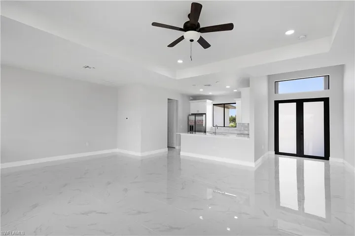 Unfurnished living room with a raised ceiling and light tile patterned floors