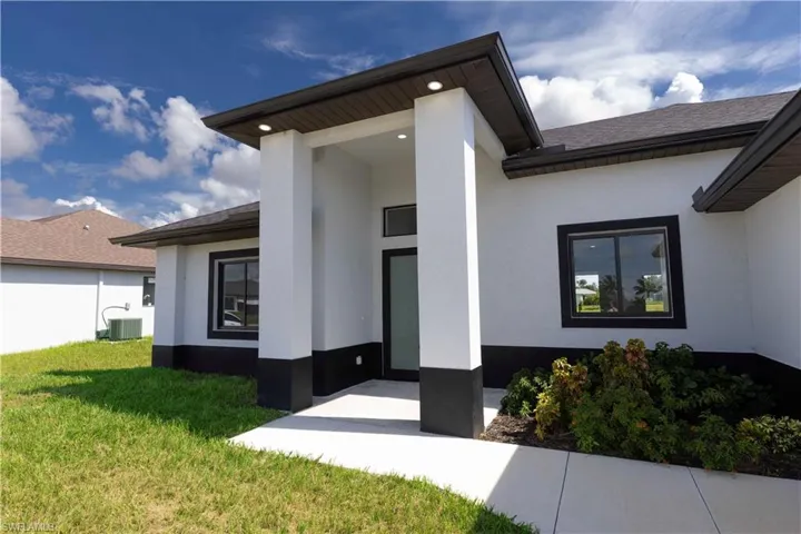 Doorway to property with cooling unit and a yard