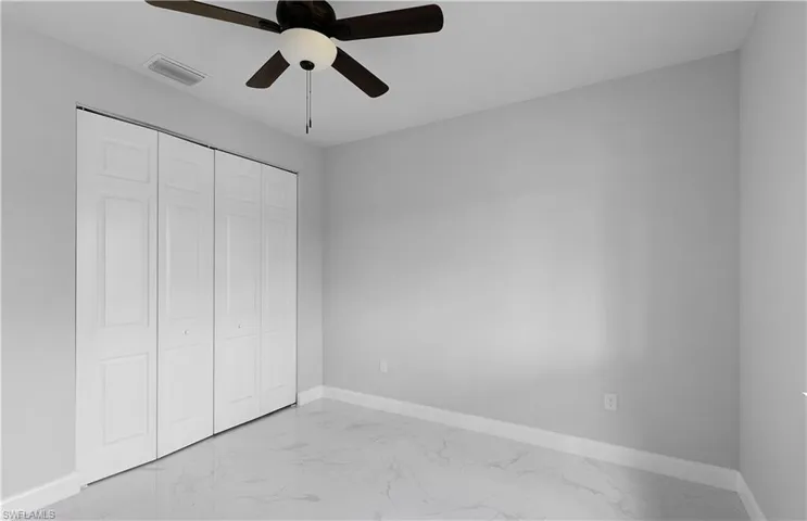 Unfurnished bedroom with ceiling fan, light tile patterned flooring, and a closet