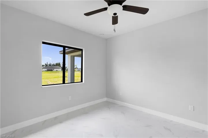 Unfurnished room featuring tile patterned flooring and ceiling fan