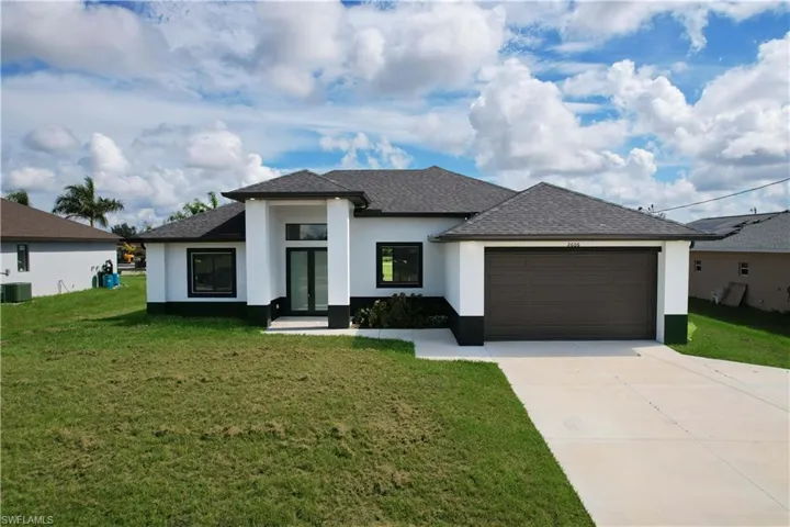 View of front of house featuring a garage and a front lawn