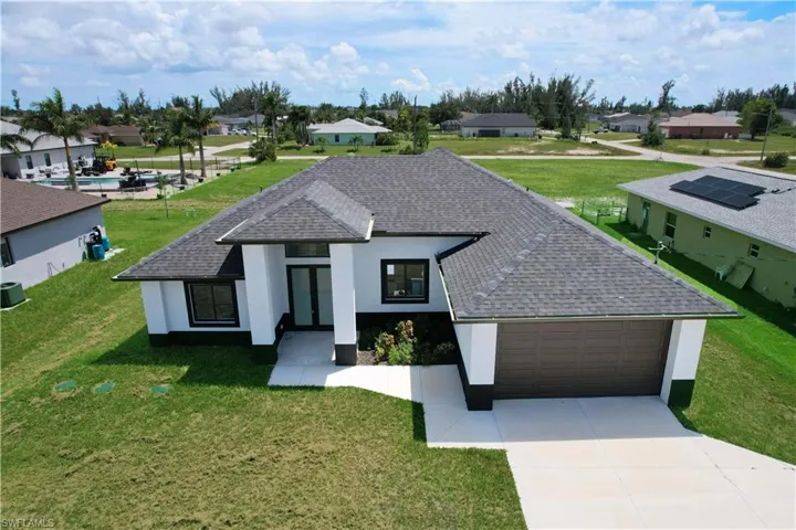 View of front of home with a garage and a front lawn