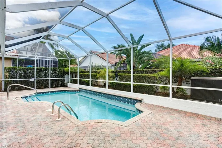 View of swimming pool featuring a patio, glass enclosure, and central AC unit