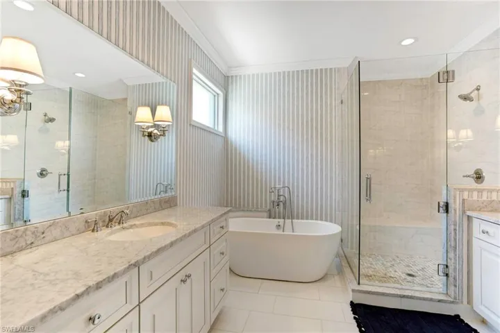 Bathroom featuring tile flooring, ornamental molding, plus walk in shower, and large vanity