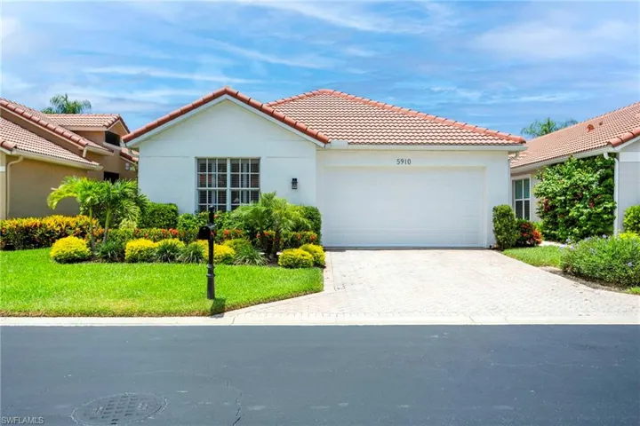Mediterranean / spanish home with a garage and a front lawn