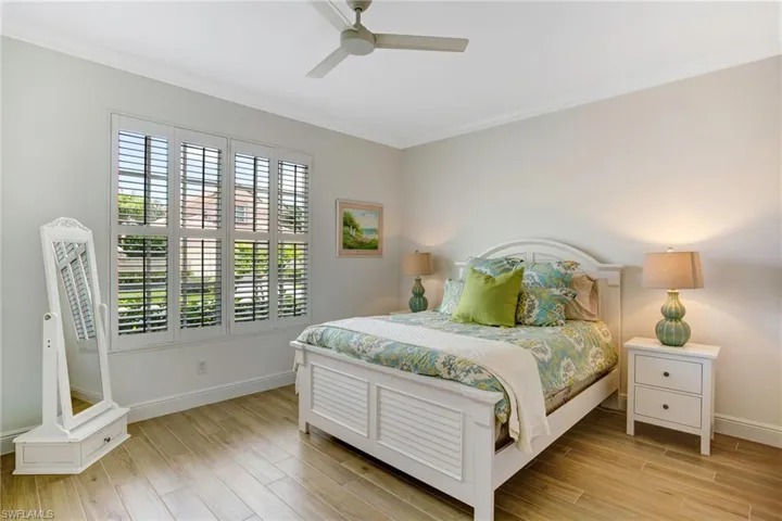 Bedroom with crown molding, ceiling fan, and light hardwood / wood-style flooring