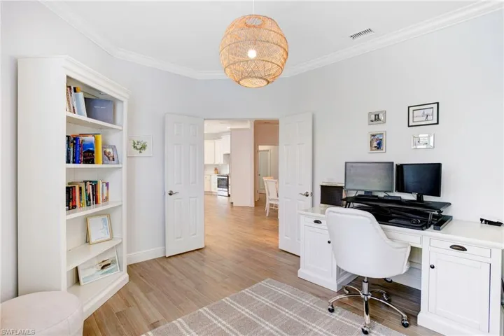 Office with crown molding and light wood-type flooring