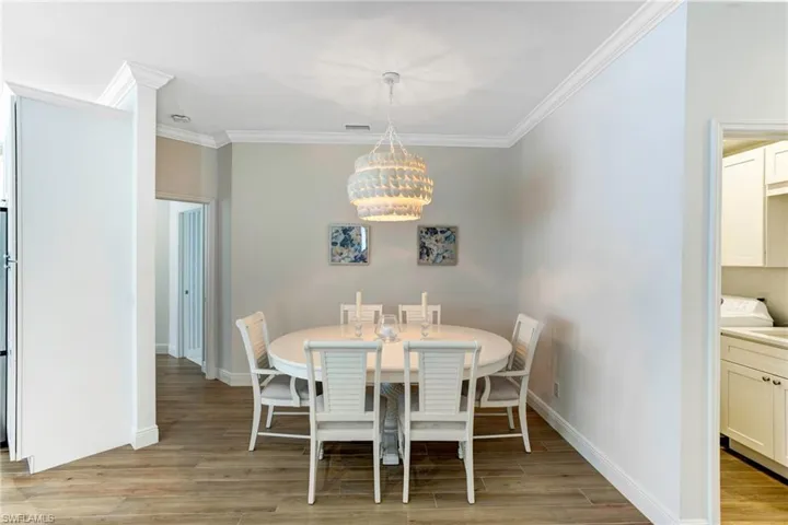 Dining room featuring ornamental molding, an inviting chandelier, and light hardwood / wood-style flooring