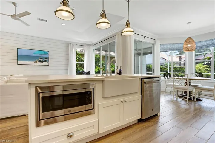 Kitchen with decorative light fixtures, appliances with stainless steel finishes, sink, and light wood-type flooring
