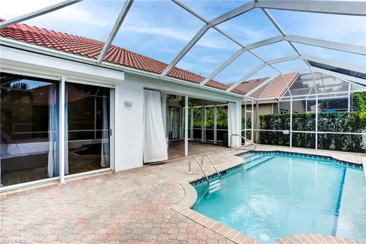 View of swimming pool with a patio area and glass enclosure