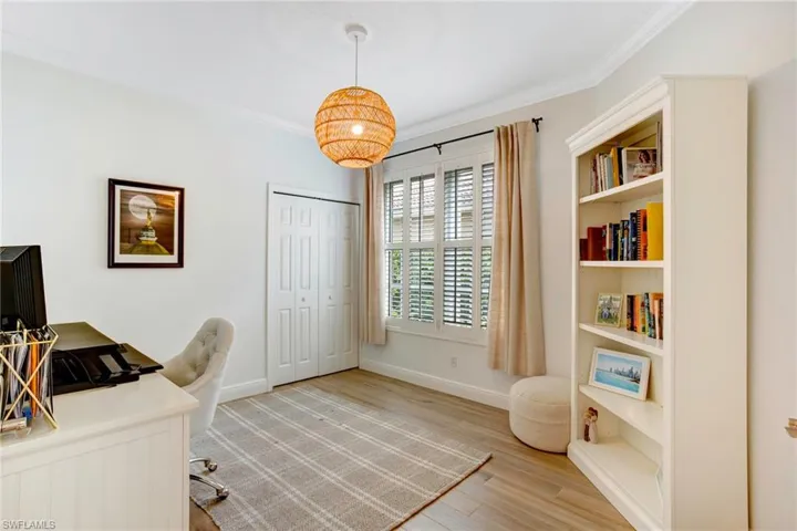 Office area featuring light hardwood / wood-style flooring and crown molding